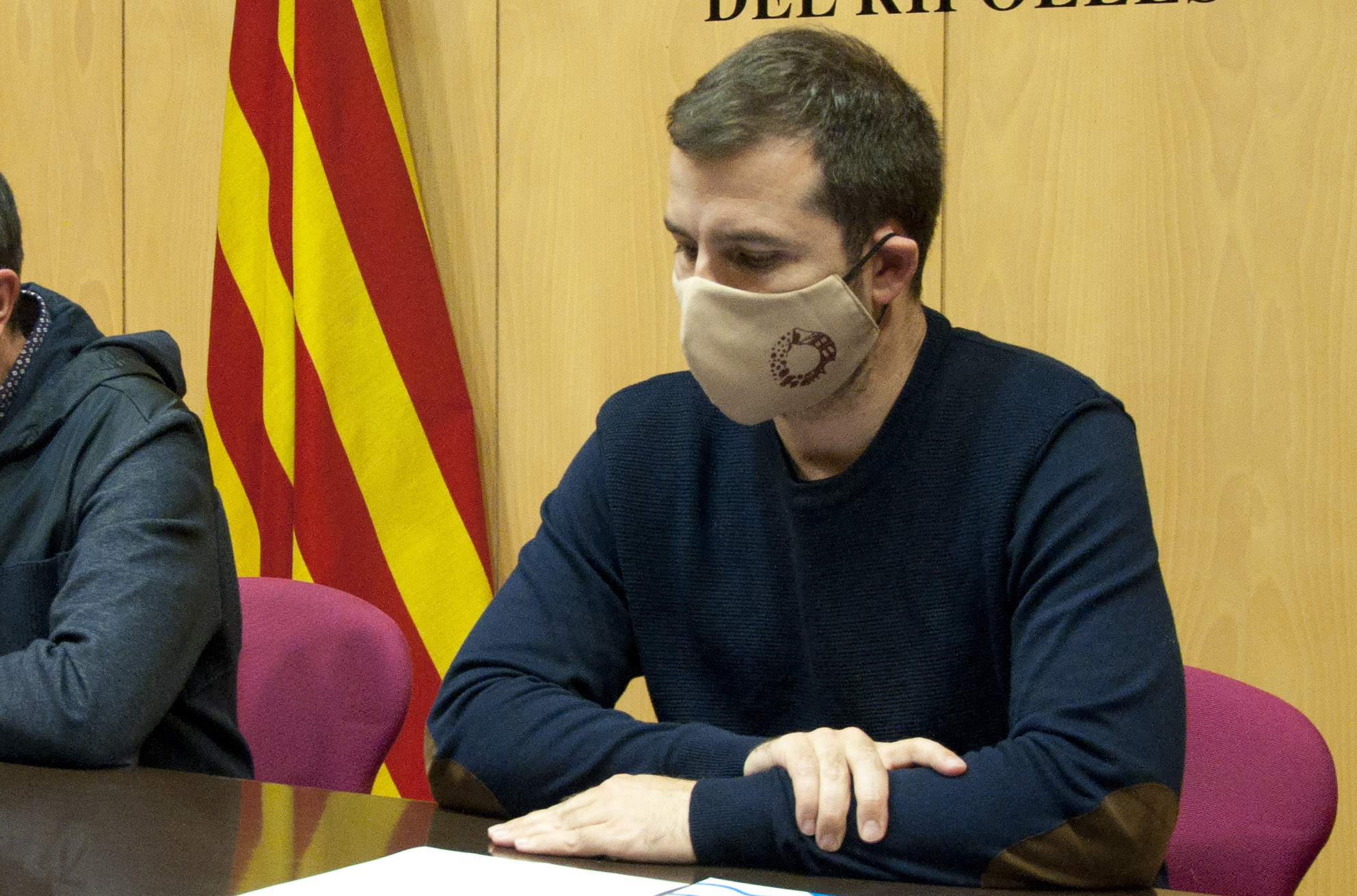 Imatge del president, Joaquim Colomer, amb una màscara amb el logotip turístic del Ripollès