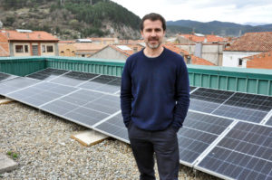 Joaquim Colomer davant les plaques solars de la coberta de l'edifici del Consell Comarcal del Ripollès