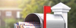 Imatge parcial d'una bústia d'estil americà amb correspondència i la bandereta vermella aixecada